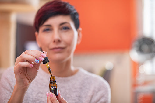 a woman with cbd drops